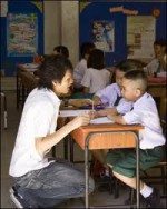 lying boy at desk with teacher