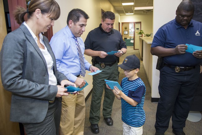 Caleb Benedetto, 6, Avondale, hands thank you cards to officers