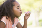 Young girl blowing bubbles outdoors