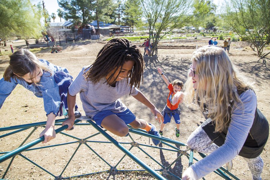 From left: Elody Prange (8), of Phoenix, and AJ Hetzer (8), of Tempe, play with Abby Loebenberg, PhD, at Desert Marigold School in south Phoenix. Photo by Tac Coluccio.