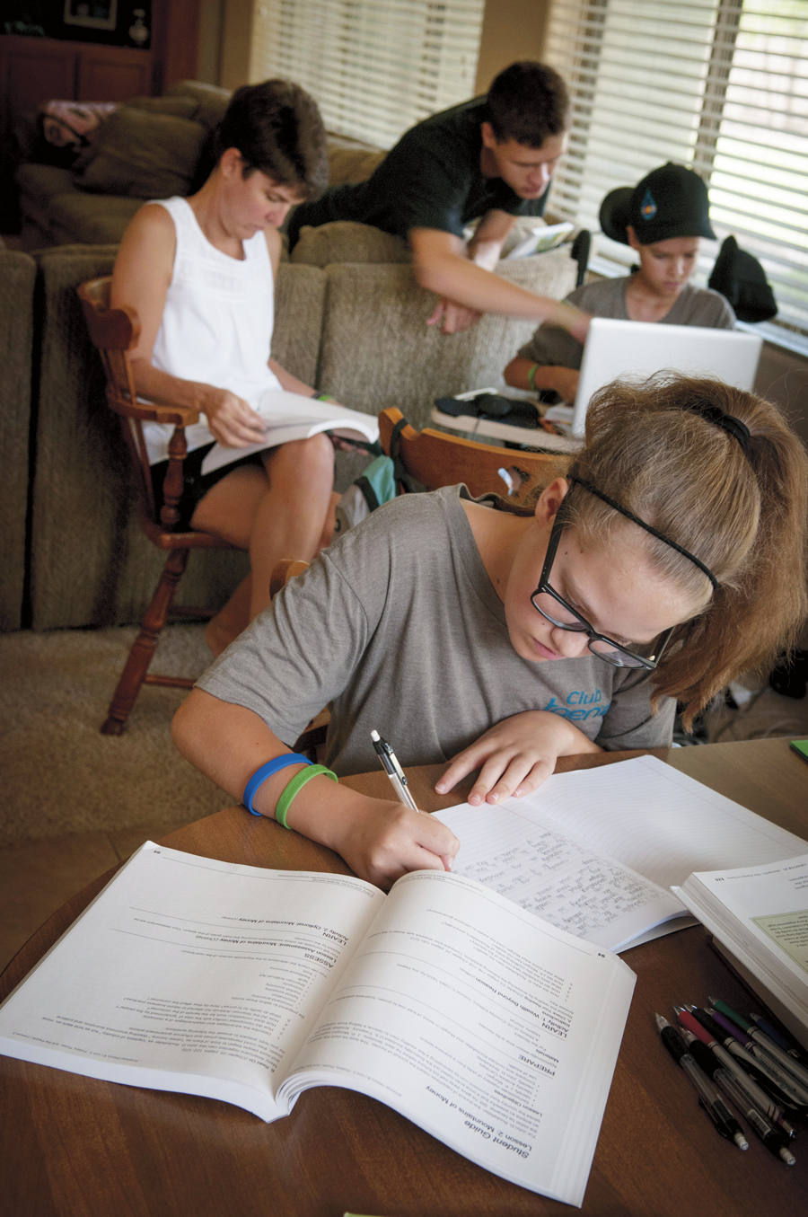 Above: Campbell Faulker (10) attends home school so his family has more flexibility around his health-care needs. Right: Campell’s sister, Sage (13) works on her home-school lesson while he tackles a challenging history assignment with help from his mom, Carrie, and education coach and brother Clayton (20).