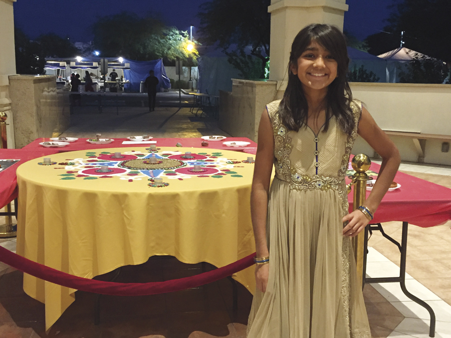 Above: Nandini beams in anticipation of opening Christmas presents. Top: Nandini stands in front of a rangoli at the Ekta Mandir temple in Phoenix during Diwali. Photos courtesy of Rudri Bhatt Patel.