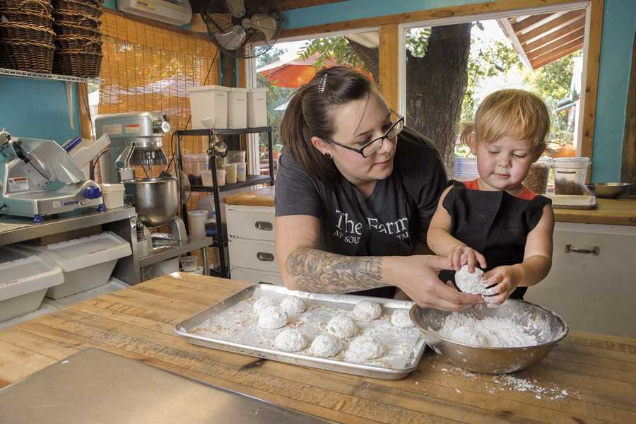 Chef Jennifer Romine with her daughter, Astrid (2) making Pecan Butterballs in the kitchen of The Farm at South Mountain. Photo by Cassandra Tomei.