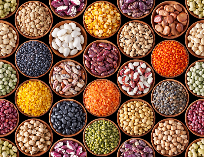 Seamless texture with legumes on black background