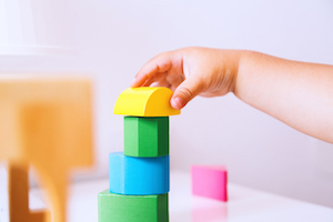 Baby playing and discovery with colorful toys at home, close-up detail.