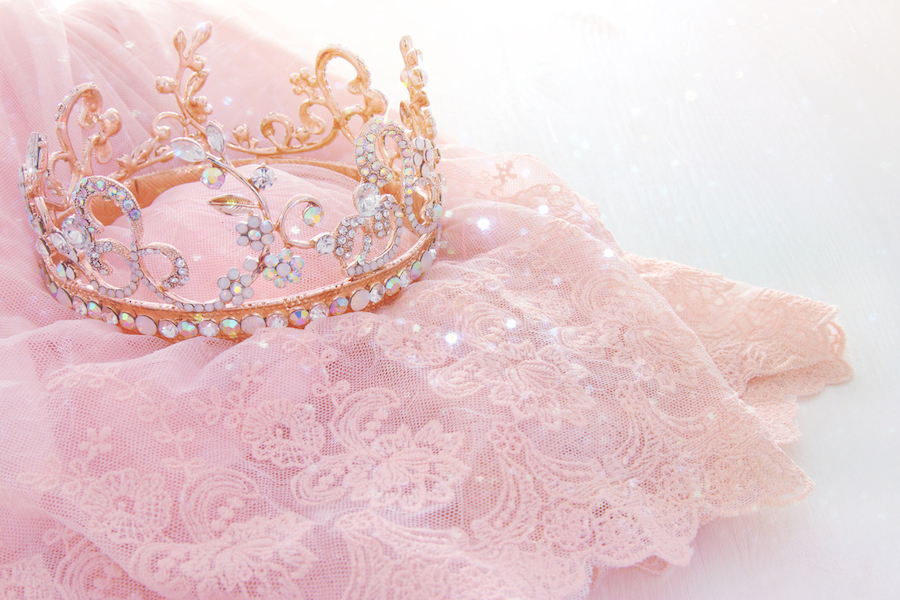 Vintage tulle pink chiffon dress and diamond tiara on wooden white table. Wedding and girl’s party concept