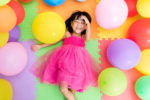 Asian Little Chinese Girl Lying on Floor amongst Balloons